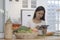 Beautiful housewife standing at kitchen counter and reading online recipe for making healthy meal. Dieting, healthy lifestyle