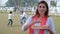 A beautiful housewife wearing a white Kurti and Chunni offers traditional Gujiya - Holi celebrations, an Indian sweet, a tasty cui