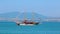 Beautiful huge wooden ship in pirate style drifts on blue surface of sea against sea coast and mountains