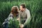 Beautiful hugging couple in love in an early wheat field