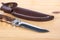 Beautiful hunting knife and sheath in the wooden table