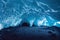 Beautiful ice cave with burrow and icicle crystals on ceiling.