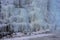 Beautiful ice structures of a frozen waterfall, pretty icicles forming an interesting pattern on a dark rock,