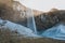 beautiful icelandic landscape with Seljalandsfoss waterfall, snow on rocks