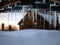 Beautiful icicles on a background of a country house and snow snowdrift. Snowing, winter