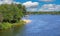 Beautiful idyllic dutch lake, boats on water, small sand beach, green forest, blue summer sky - Leukermeer, Limburg, Netherlands