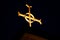 Beautiful illuminated golden cross atop a church at night time with darkened sky in background