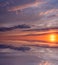 Beautiful illuminated sky at sunset, multi-colored clouds and bright sun over a calm sea