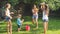 Beautiful image of happy laughing family with children having fun at hot summer day with water guns and garden hose