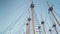 Beautiful image of high mast of historical wooden ships and boats against blue sky