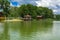 A beautiful image of a landscape from the center of a river surrounded by trees and reeds on the shore against a blue sky in