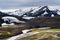 Beautiful impressive landscape with snow covered mountain and natural stream in summer season