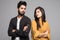 Beautiful indian couple standing apart from each other while being in a quarrel isolated on grey background