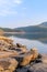 Beautiful Indian lake with mountains in the background and rocks in the four Brown with beautiful blue sky and crystal clear water