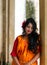 Beautiful indian woman in orange saree standing with a sad mood . concept of broken heart. Valentine`s Day love and faith