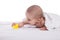 Beautiful infant playing with small yellow duck after shower, is