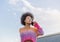 Beautiful intellectual style afro haired girl talks to her mobile phone representing freedom