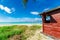 Beautiful inviting Cuban Varadero beach and tranquil turquoise ocean with brownish red wooden shed