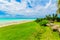 Beautiful inviting view from tropical garden on Cuban Varadero beach, tranquil turquoise tender ocean against blue sky background