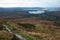 Beautiful irish landscape seen from the top of a hill. Green fields, stone path and the athlantic ocean in the background