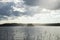 A beautiful island with trees on the huge lake. Rain at sunset makes the sky shine