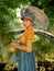 Beautiful Jane Austen style woman strolling through a park