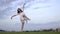 Beautiful Japanese girl in white dress is engaged in ballet on the lawn, slow-motion