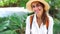 Beautiful joyful tourist woman in straw hat and white shirt looking and smiling at camera