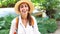 Beautiful joyful tourist woman in straw hat and white shirt looking and smiling at camera