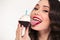 Beautiful joyful young woman with retro hairstyle eating birthday cupcake