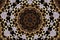 Beautiful kaleidoscopic pattern of a gold embroidery on wood