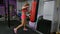 Beautiful Kickboxing woman training punching bag in fitness gym