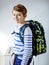 Beautiful kid boy with schoolbag rucksack standing in room in early morning. Happy healthy child on the way to lessons