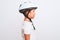 Beautiful kid boy wearing bike security helmet standing over isolated white background looking to side, relax profile pose with