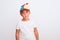 Beautiful kid boy wearing fanny colorful cap with propeller over isolated white background with serious expression on face