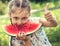 Beautiful kid girl eating big red watermelon with fun humor look