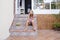 Beautiful kid girl eating watermelon on stairs at home. Family love and lifestyle outdoors