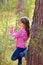 Beautiful kid girl looking plants in forest