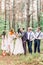 Beautiful kissing couple newlyweds with their friends having fun together. Happy bridesmaids and groomsmen with bride