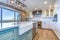 Beautiful kitchen room with green island and farm sink.