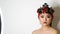 Beautiful Korean Asian girl in a trendy red turban with bright evening make-up smoky eyes posing in studio on a white
