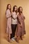 beautiful ladies in dress stand in descending order leaned on each other, isolated
