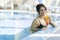 Beautiful lady drinking a cocktail in a swimming pool and relaxi