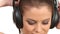 Beautiful lady listening music in large headphones, looking at camera
