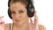 Beautiful lady listening music in large headphones, looking at camera and making blow kisses