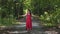 Beautiful lady in red dress raising hands in forest, power of nature, unity joy