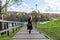 A beautiful lady stands and leans on the railing, an adult with a charismatic appearance in black clothes, in the fall