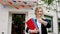 Beautiful lady student with a large charismatic smile holding some maps in hands she looking straight to the camera