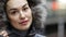 Beautiful lady in winter jacket with faux fur trim hood stands on metro platform