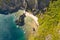 Beautiful lagoon surrounded by cliffs.Aerial drone view of swimmers inside a tiny hidden tropical lagoon surrounded by